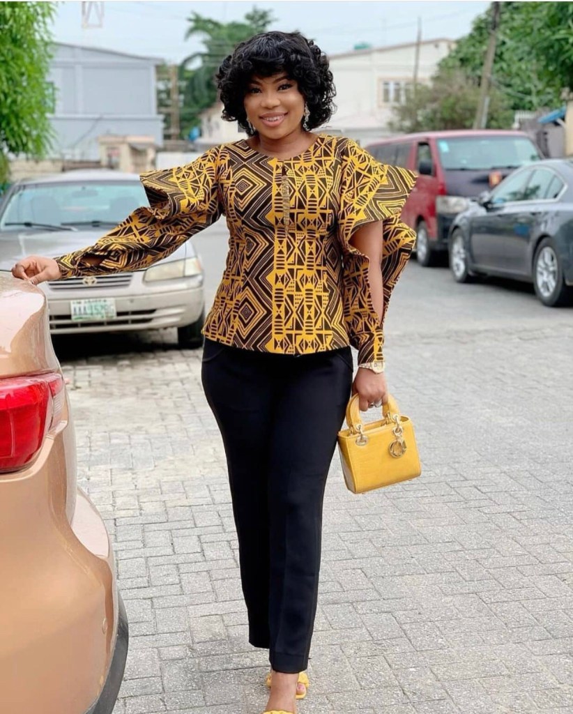 Mulher usando blusa de capulana ​