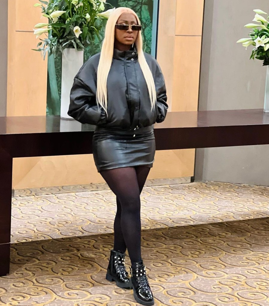 Cantora Liloca usando look preto e uma prótese capilar loira