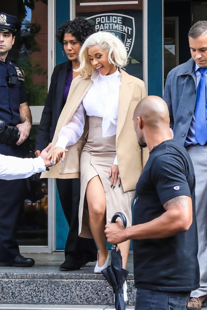 Cardi B saindo do tribunal usando look branco e marrom