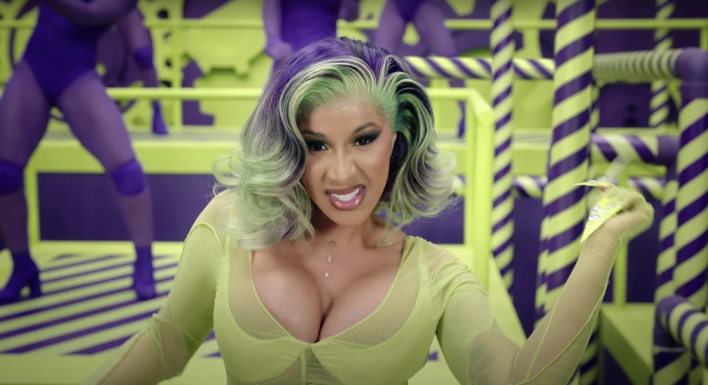 Cardi B usando penteado roxo e verde no clipe de Wap