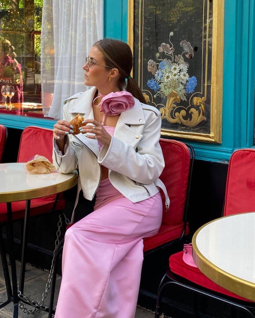 Mulher usando calça cor de rosa com jaqueta branca de couro
