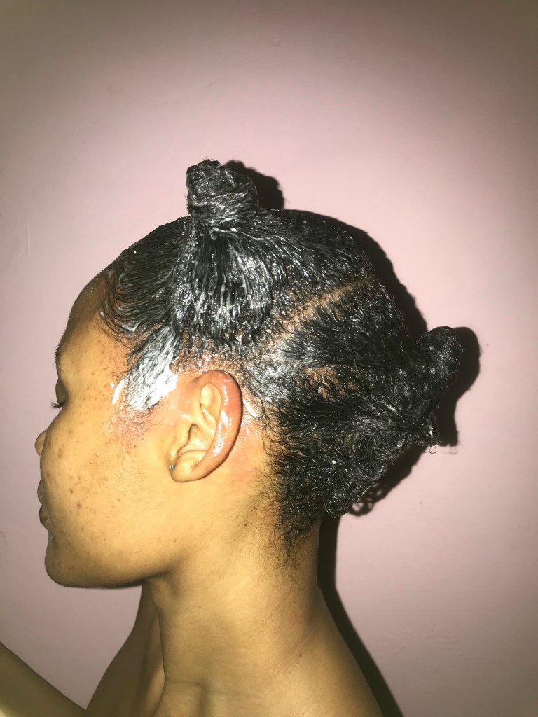 Mulher no processo de relaxamento do cabelo crespo 4c