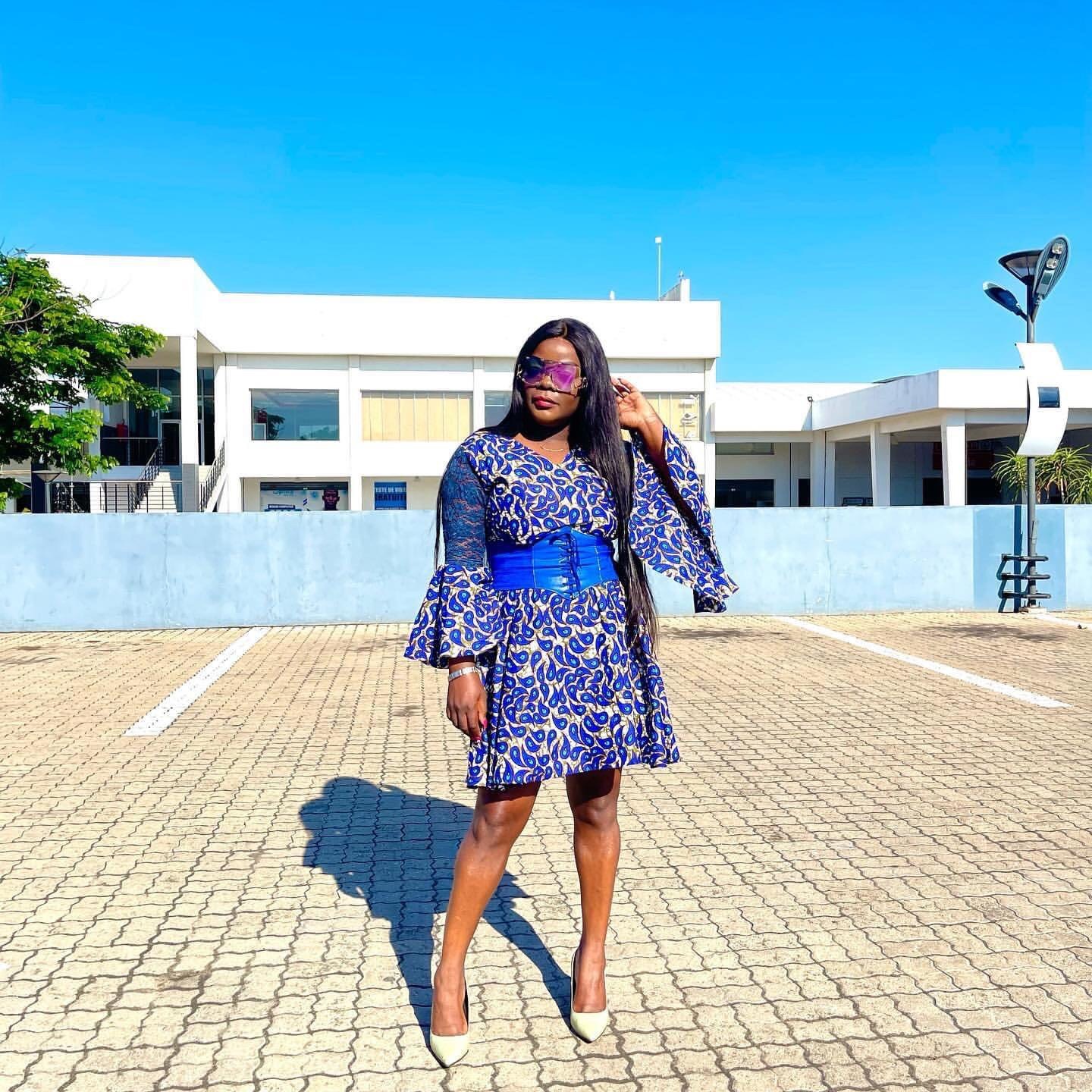 Lourena Nhate usando vestido azul com estampa  e cinto de couro azul