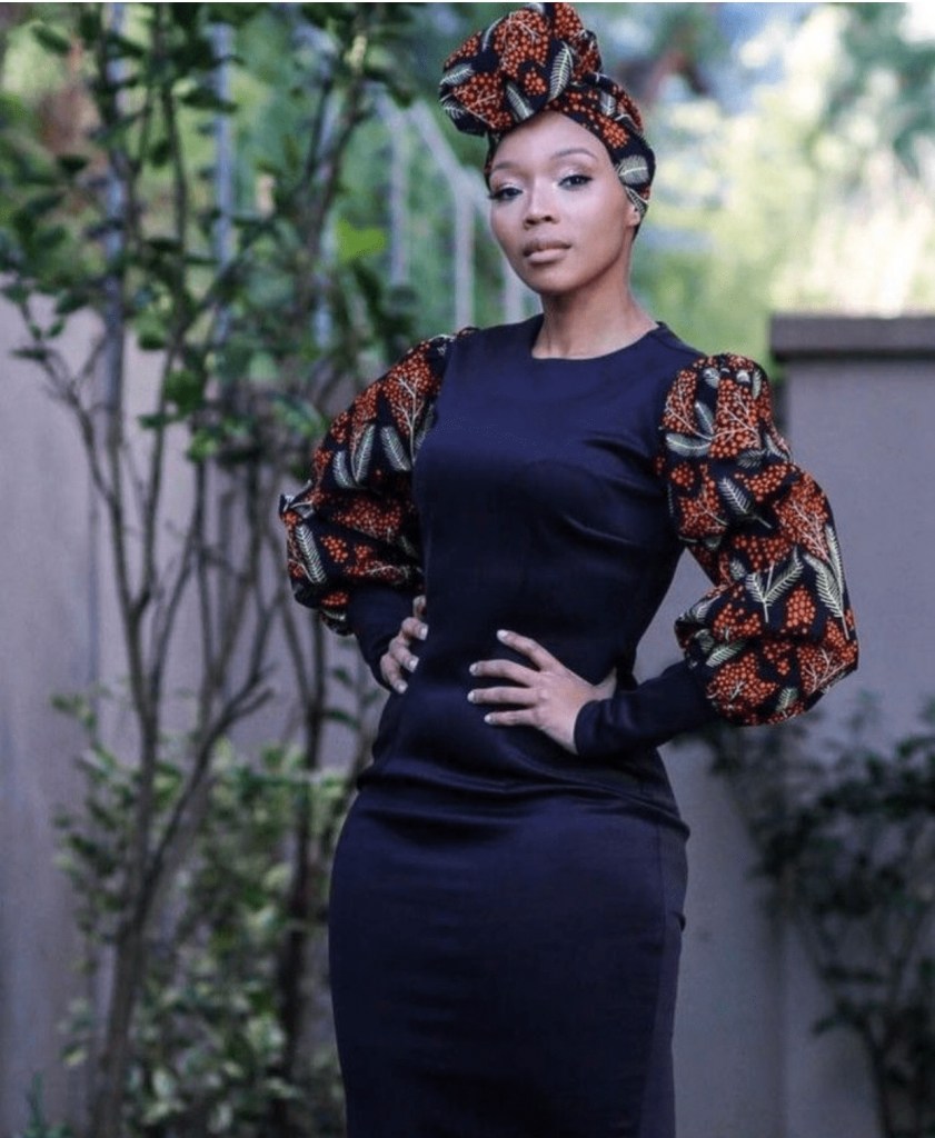 Vestido preto com detalhes em capulana nas mangas compridas